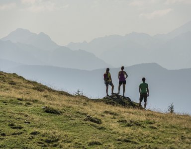Drei Wanderer genießen die Aussicht auf neblige Berglandschaft