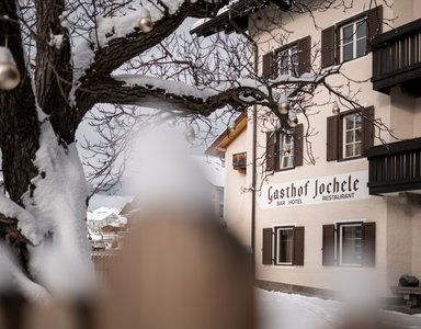 Schneebedeckter Baum vor Gasthof Jochele im Winter