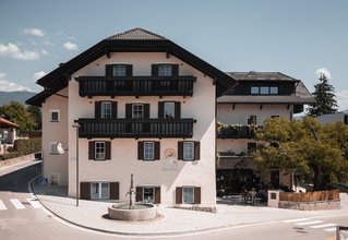 Vecchio edificio con fontana e albero su strada tranquilla