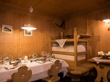 Zona pranzo accogliente con mobili in legno e tavolo apparecchiato in stile antico