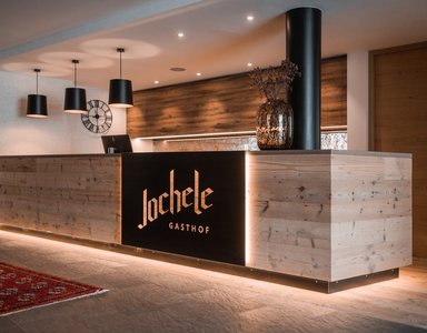 Moderne Empfangstheke im Gasthof Jochele mit Holz- und Lichtelementen