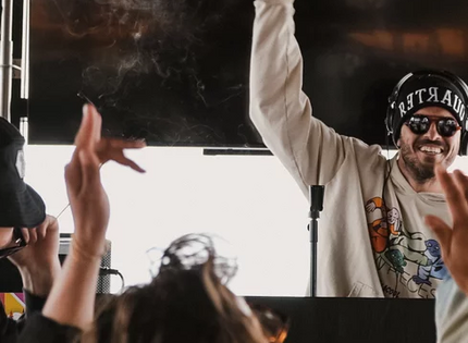 DJ con cappello e cuffie suona musica a festa con folla che balla