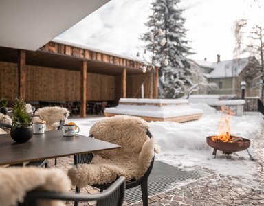 Winterterrasse mit Kamin und Stühlen mit warmen Decken