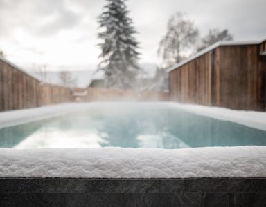 Beheizter Außenpool mit Schnee bedeckt in Winterumgebung