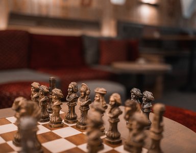 Detailaufnahme eines antiken Schachspiels auf einem Tisch in gemütlicher Umgebung