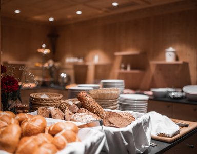 Verschiedene Brote und Brötchen auf einem Buffet in einem rustikalen Raum