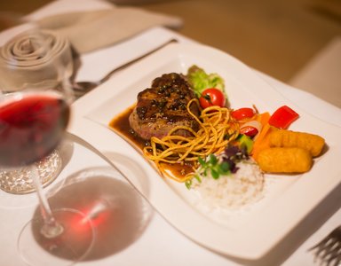 Gourmetsteak mit Reis, Gemüse und Rotwein im Restaurant serviert