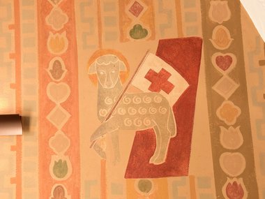 Affresco di agnello con croce rossa su parete decorata