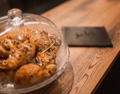 Frische Croissants unter einer Glasglocke auf einem Holztisch