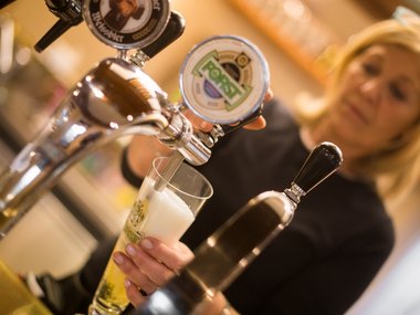 Donna che serve una birra Forst alla spina